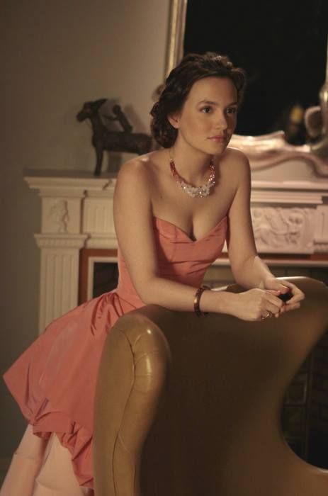 a woman in a pink dress sitting on a chair