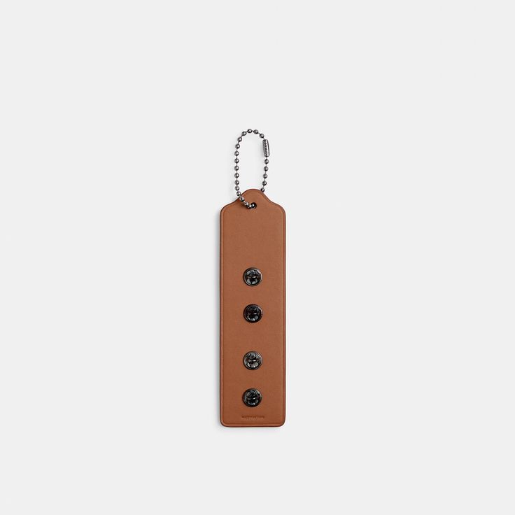 a brown leather tag with three black buttons