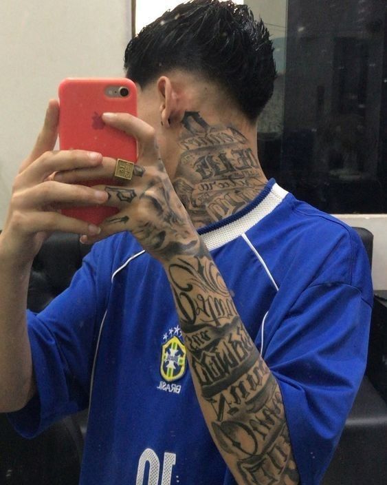 a man with tattoos on his face taking a selfie in front of a mirror