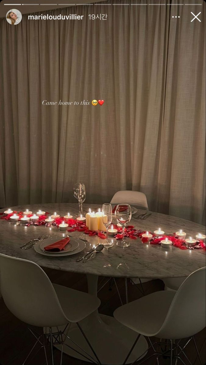 the table is set with candles and flowers on it for a valentine's day dinner