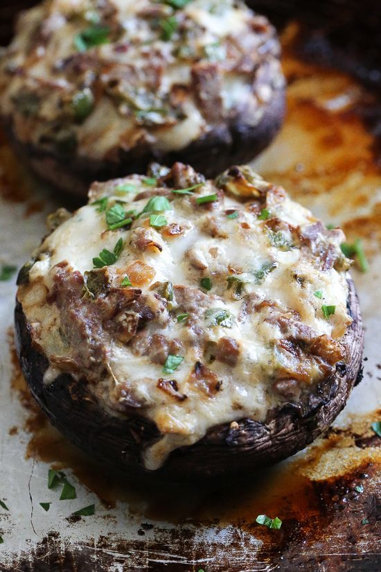 two stuffed mushrooms covered in cheese and herbs