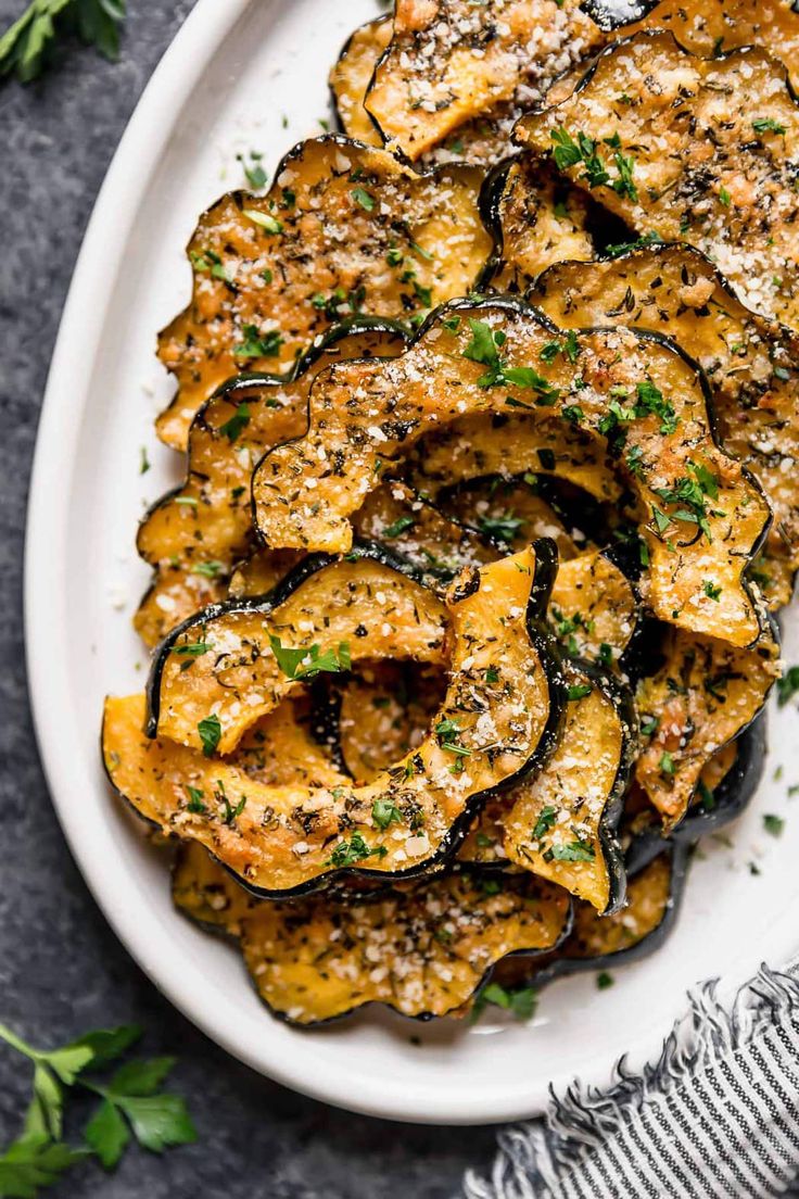 roasted eggplant wedges with parmesan cheese and herbs on a white plate