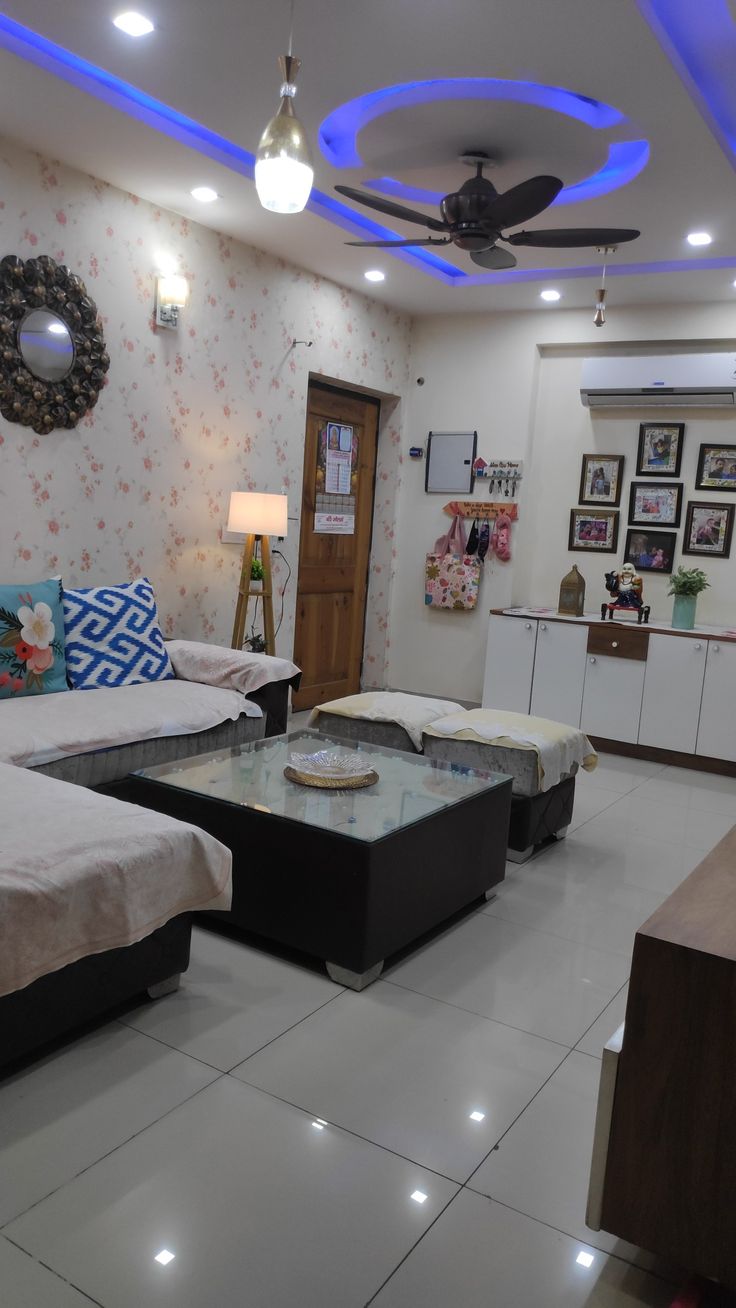 a living room filled with furniture and decor on top of white tile flooring next to a doorway