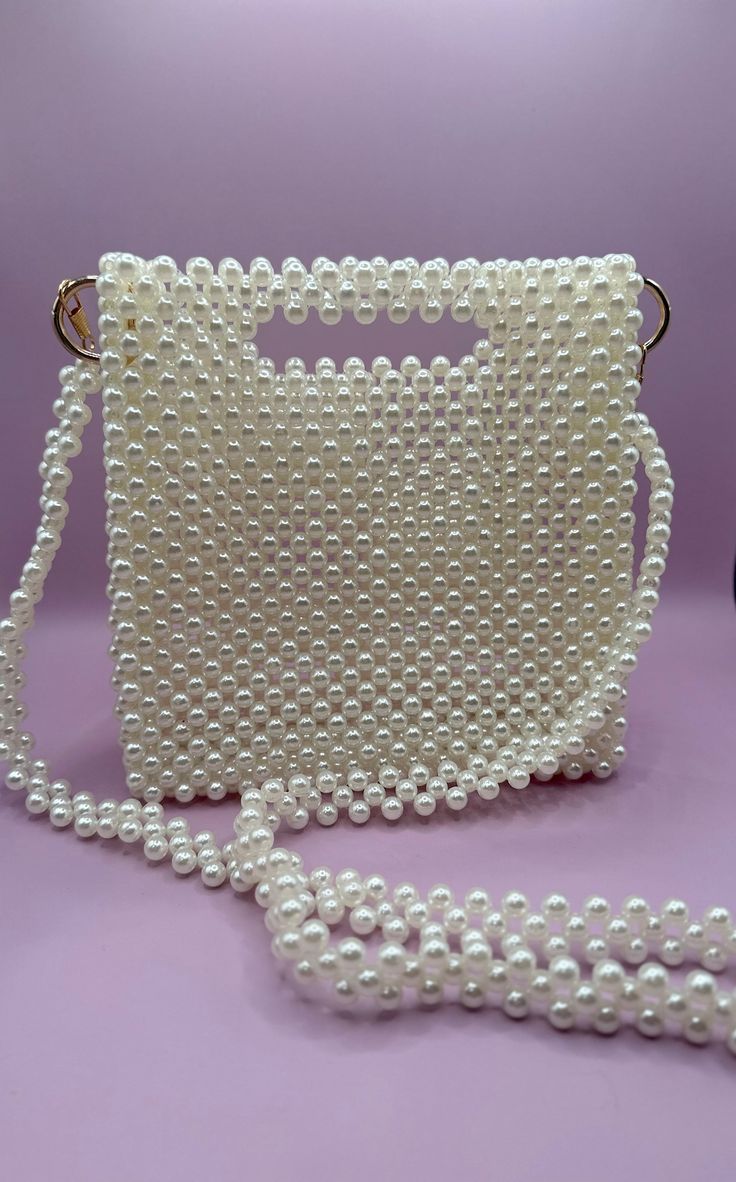 Handmade bead bag in ivory pearl with a gold accent🤍🕊️ All handbags are unique in design and color. Custom requests accepted with 3 months lead-time.  Satisfaction guaranteed.  Returns and exchanges accepted within 21 days of delivery. White Handheld Bag With Pearl Handle, White Handheld Shoulder Bag With Pearl Handle, White Shoulder Bag With Pearl Handle, White Tote Bag With Pearl Handle, White Tote Shoulder Bag With Pearl Handle, Pearl Handle Tote Bag For Gift, Square Shoulder Bag With Pearl Handle As Gift, White Rectangular Shoulder Bag With Pearl Handle, White Rectangular Bag With Pearl Handle