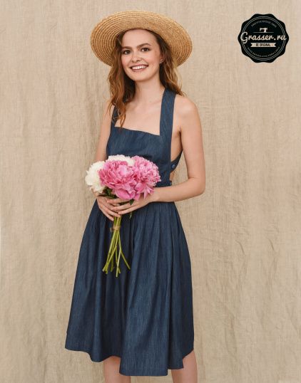 a woman in a straw hat holding a bouquet of pink and white carnations