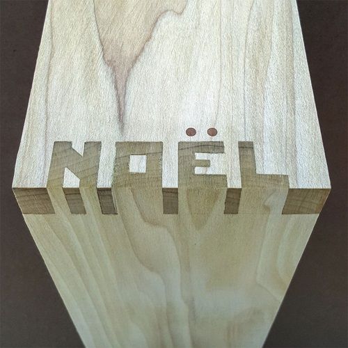 a wooden object with the word noel on it