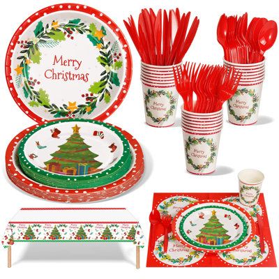 christmas dinnerware set with red and green plates, cups, napkins and utensils