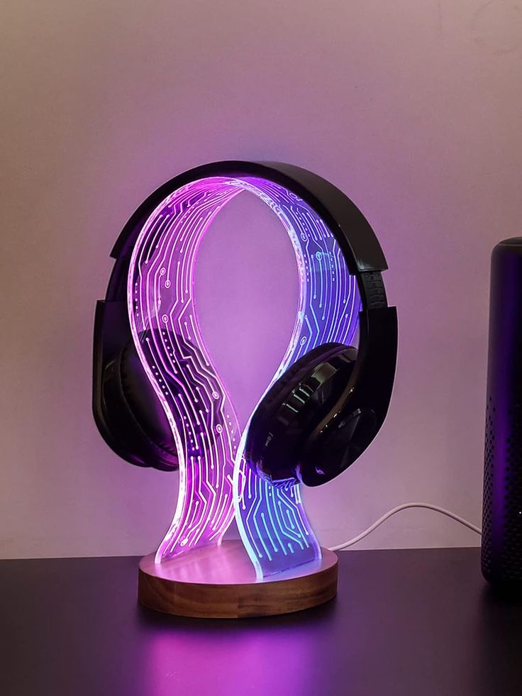 a purple and black headphone sitting on top of a wooden table next to a speaker