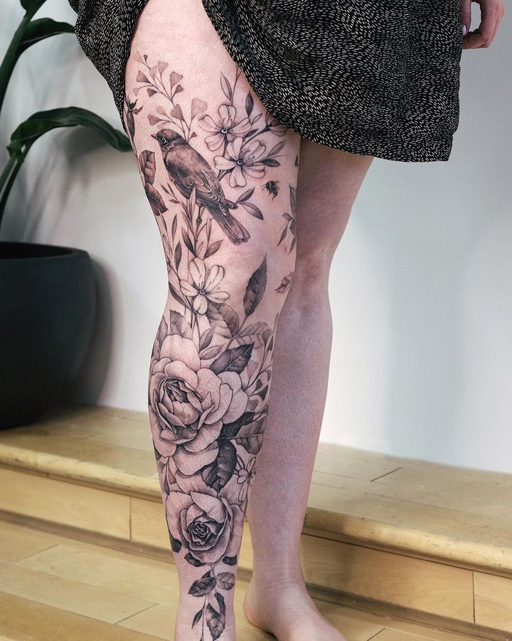 a woman's legs with flowers and birds on them