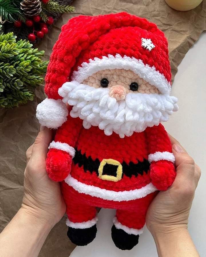 someone is holding up a crocheted santa clause