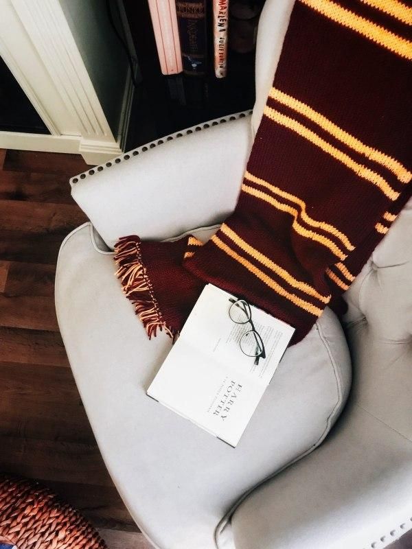 a pair of glasses sitting on top of a white chair next to a brown and yellow striped scarf