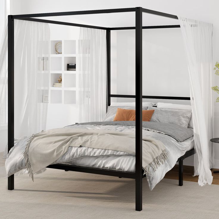 a four poster bed in a white bedroom