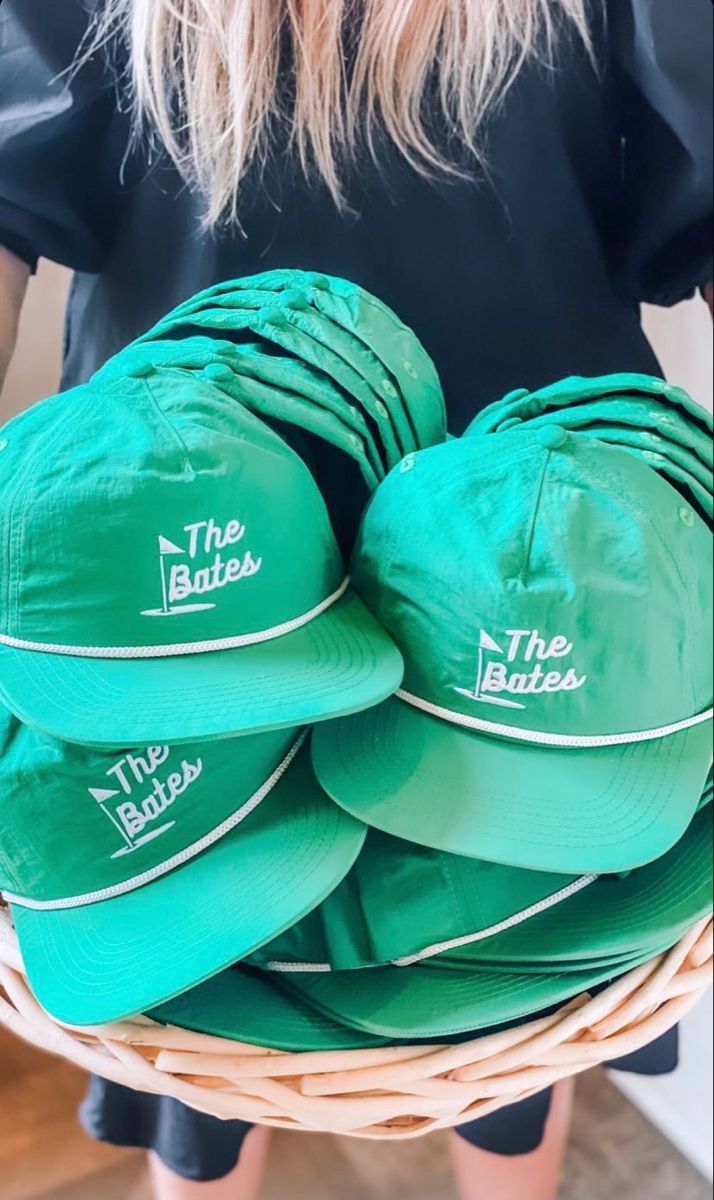 a woman holding a basket full of green hats