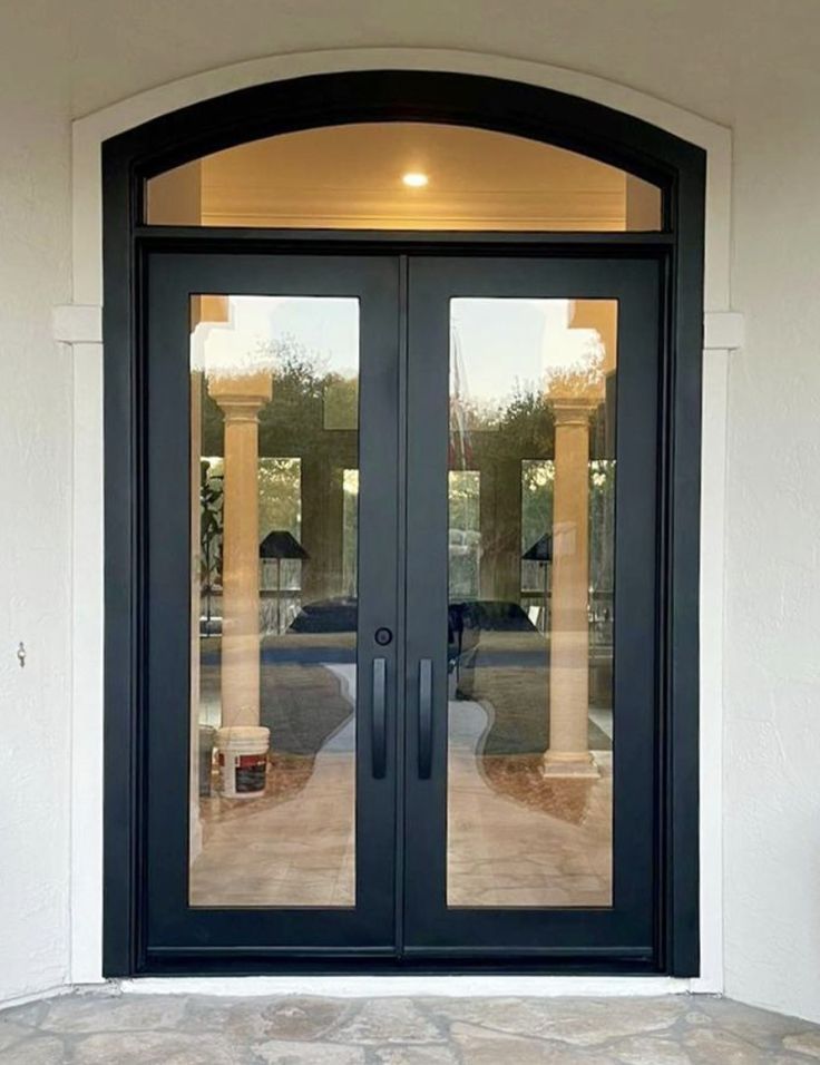 a black double door with glass on the front and side doors are open to let in light