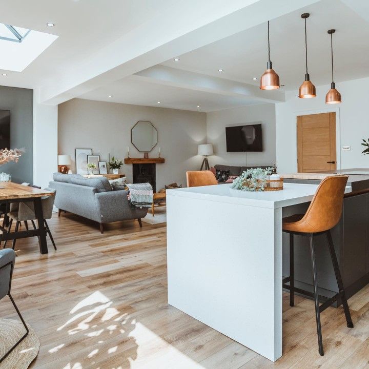 an open concept kitchen and living room with wood flooring in a modern style home