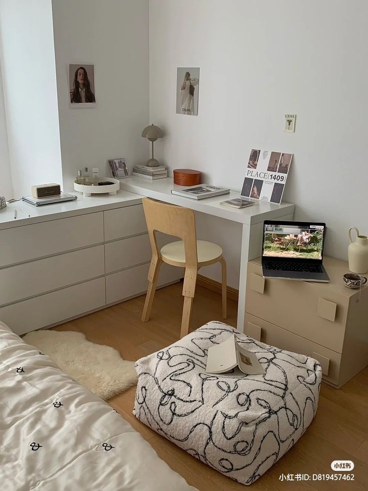 a bedroom with a bed, desk and laptop computer on the dresser next to it