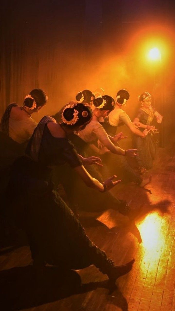 a group of people sitting on top of a wooden floor in front of a fire