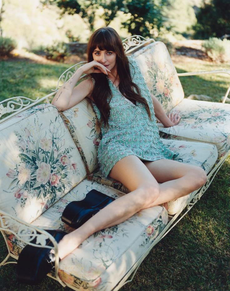 a woman sitting on top of a couch in the grass