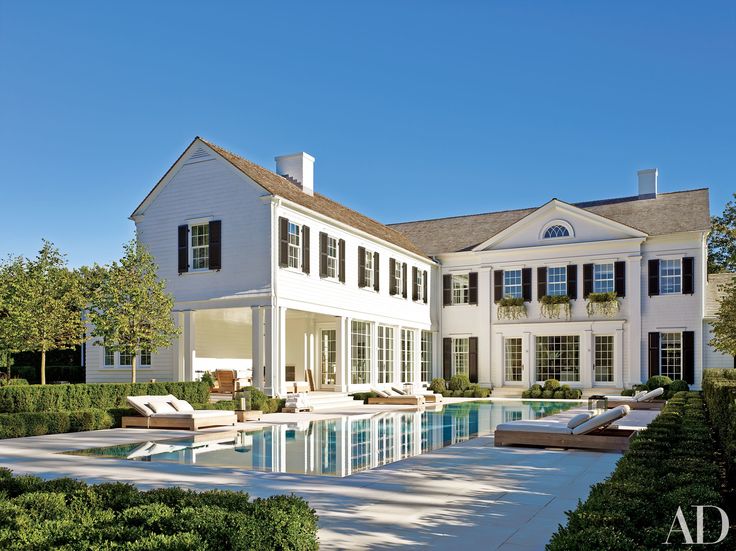 a large white house with a pool in front of it