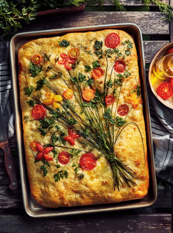 a square casserole topped with tomatoes and herbs