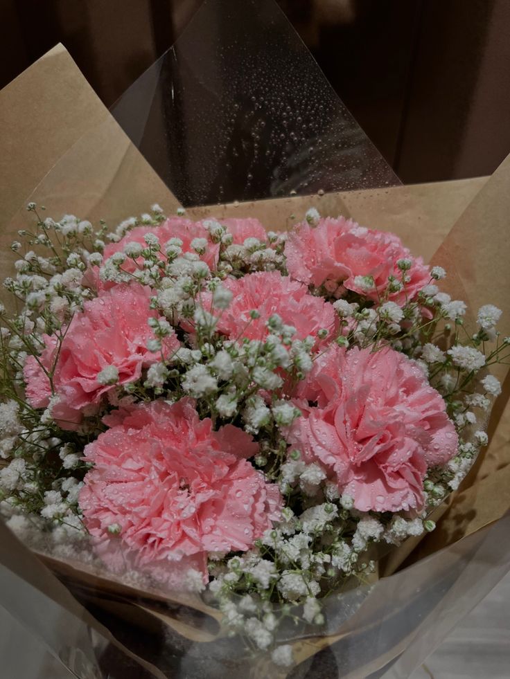 pink carnations and white baby's breath in a bouquet