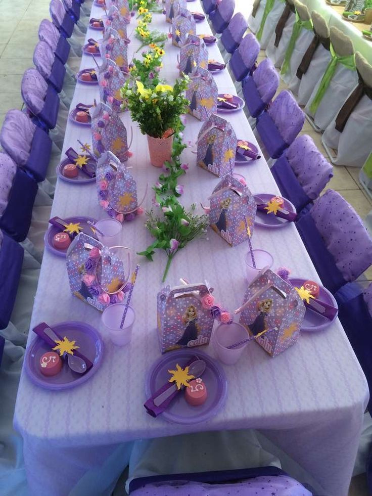 a long table with purple chairs and decorations