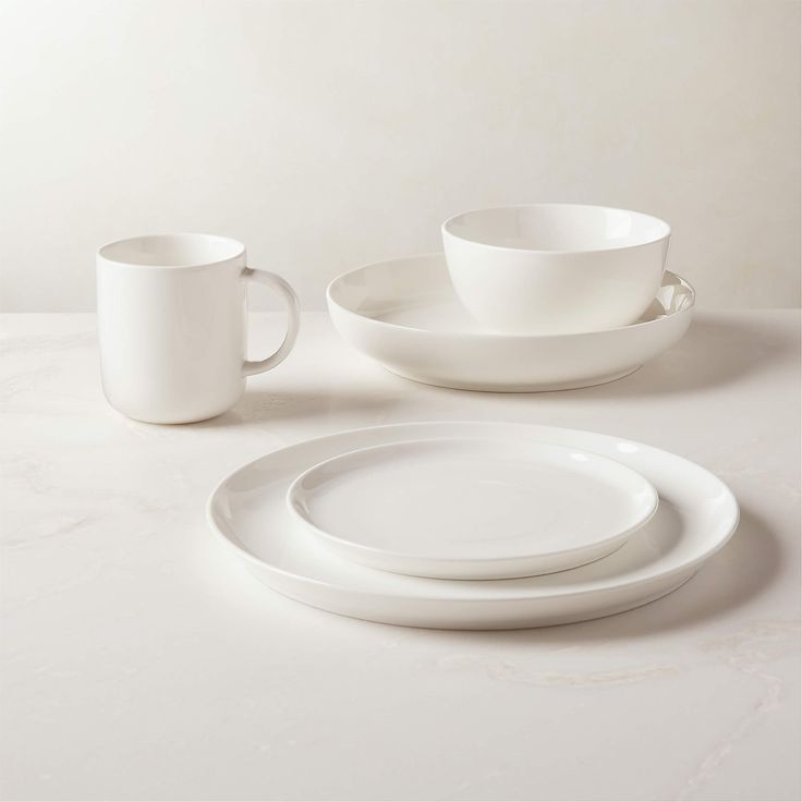 white dishes and cups sitting on top of a table