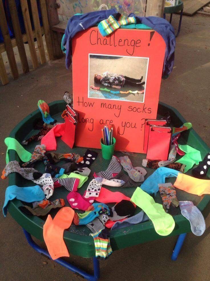 a green table topped with lots of different types of shoes and socks on top of it