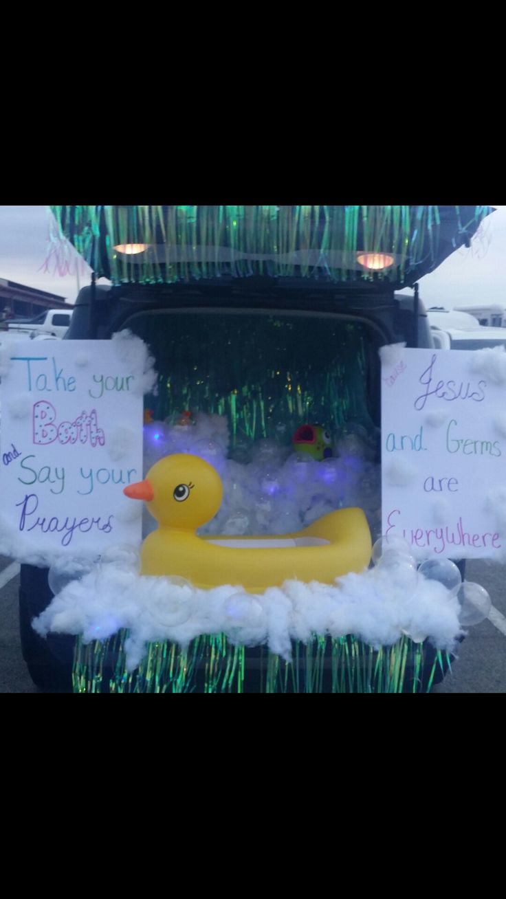 a yellow rubber ducky sitting in the back of a car with some signs on it