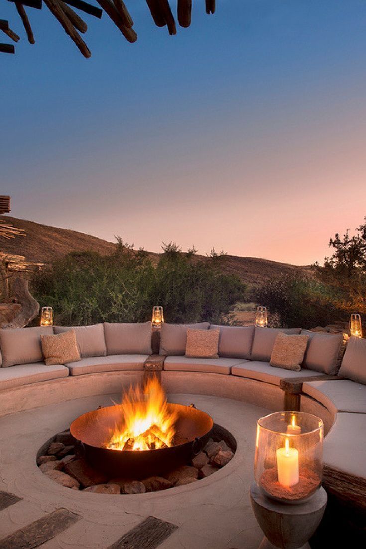 an outdoor fire pit with candles lit on it