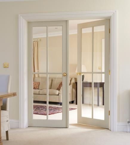 an open door leading to a living room with a couch and table in the background