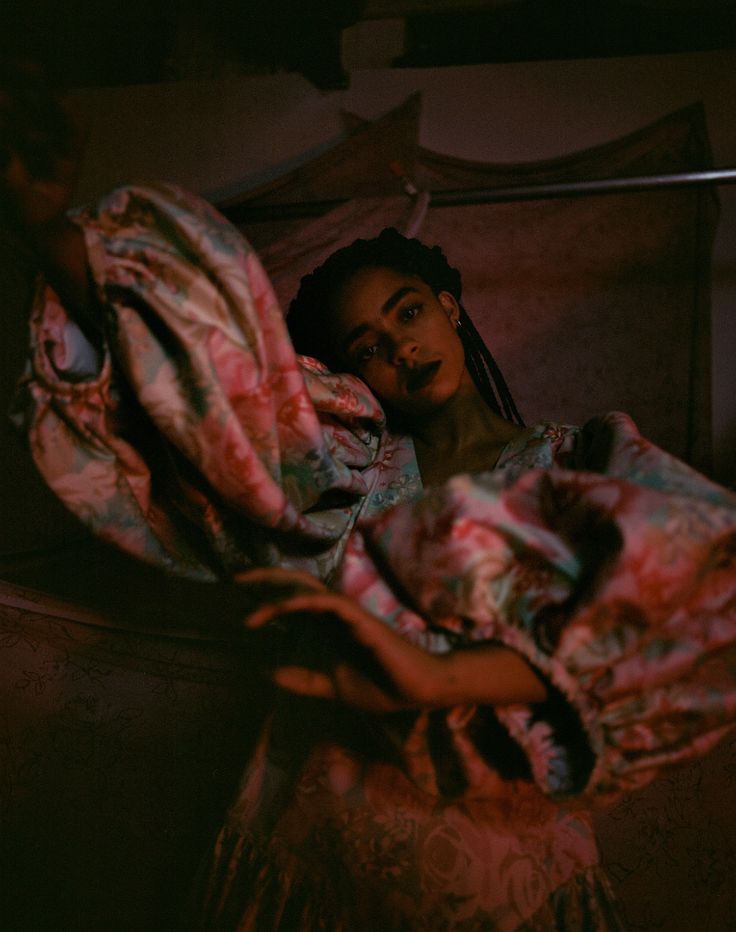 a woman laying in bed under a blanket