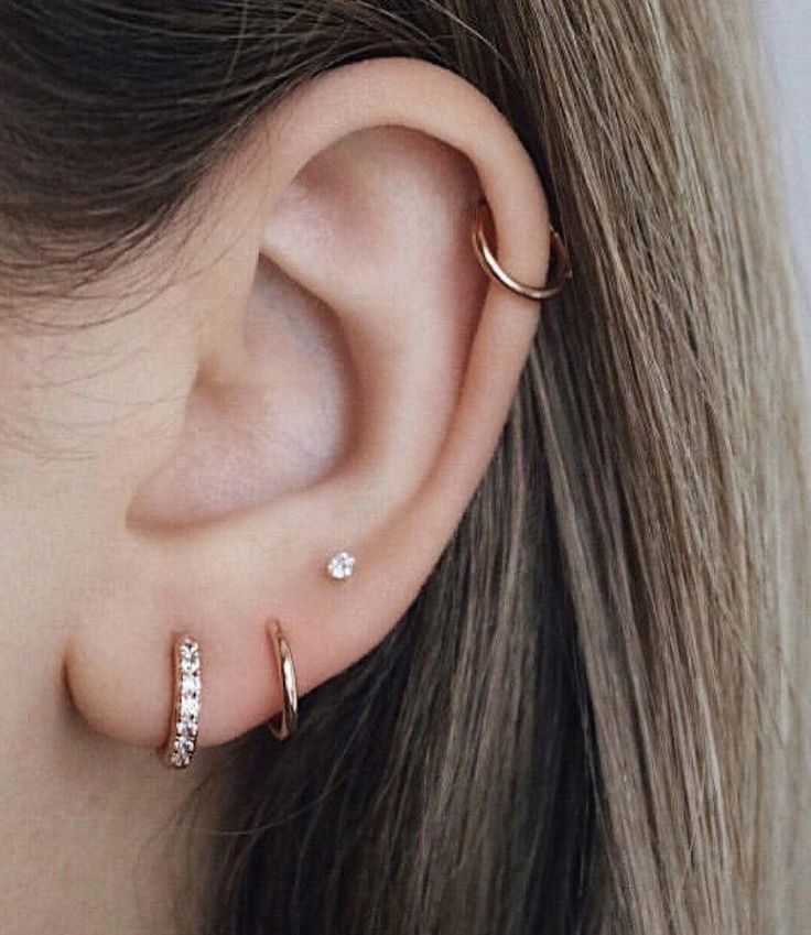 a close up of a person's ear with two different types of piercings