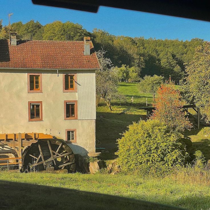 an old house with a water wheel in front of it