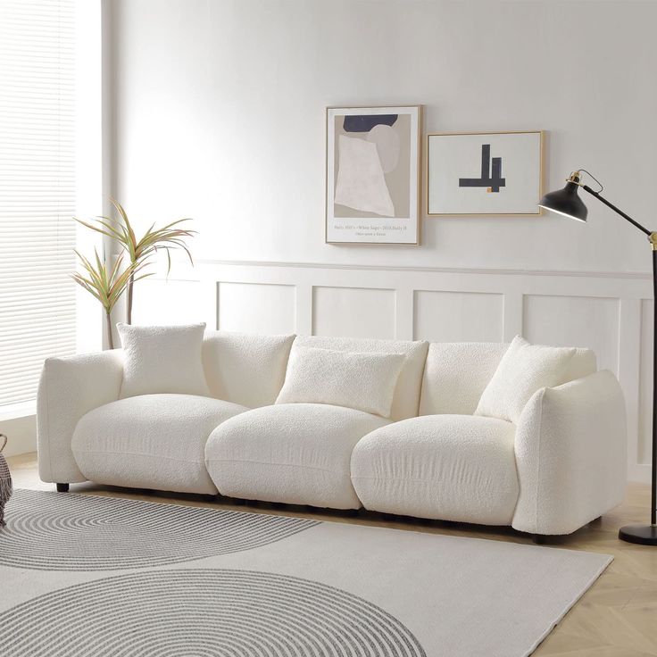 a living room with white couches and rugs