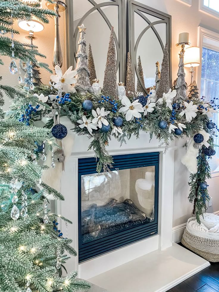 a fireplace decorated for christmas with blue and white decorations