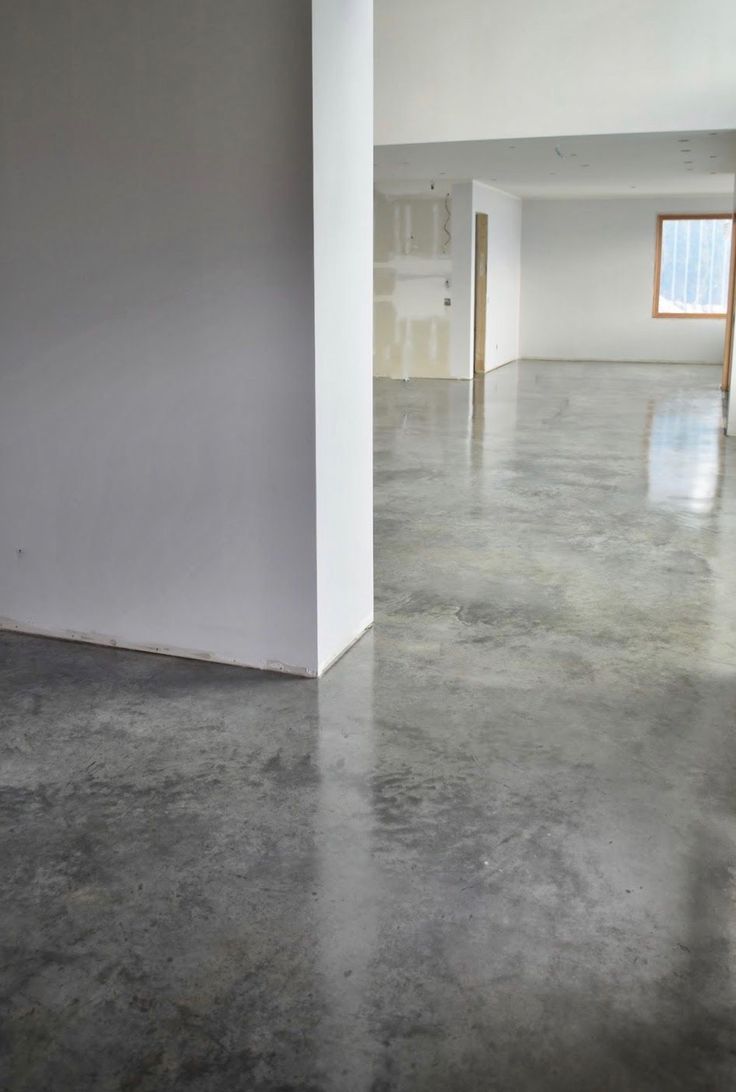 an empty room with concrete floors and white walls