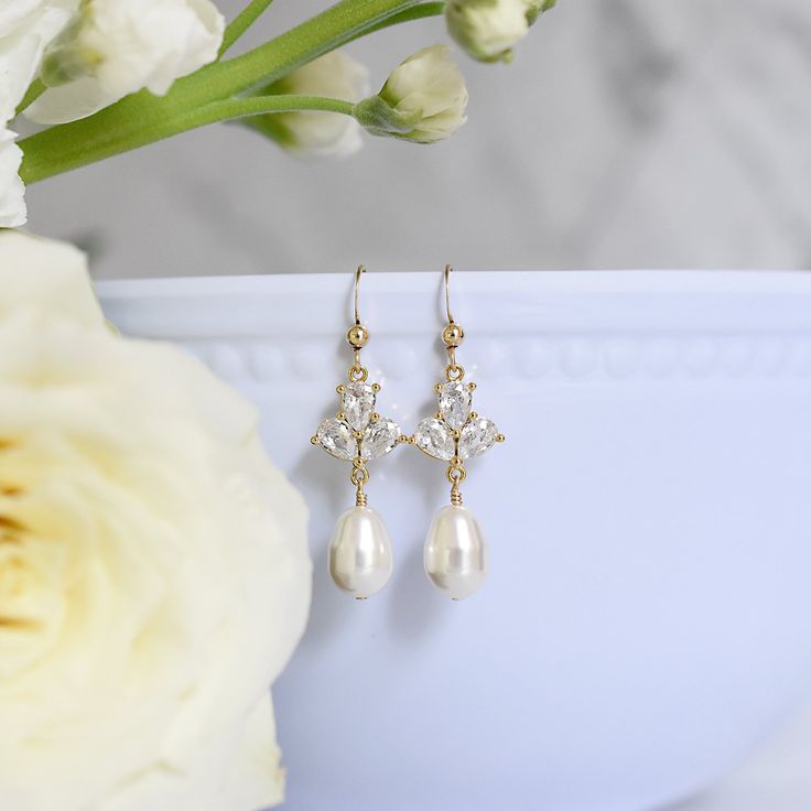 Dainty yet glamorous, The Rose Earrings in Gold, are the perfect accessory to accent a bateau neckline for both you and your bridesmaids. The subtle sparkle adds a touch of elegance to your wedding day look. Size: 1.5" long Materials: cubic zirconia, Swarovski pearls in white Metals: gold filled ear wires and components Find the matching necklace here Elegant Formal Bridal Accessories With Pearl Drop, Elegant Drop Crystal Earrings For Wedding, Elegant Drop Earrings For Anniversary Bridal Accessories, Elegant Sparkling Earrings For Wedding, Elegant Bridal Drop Earrings For Anniversary, Elegant Sparkling Wedding Earrings, Elegant Hypoallergenic Crystal Earrings For Formal Occasions, Formal Bridal Accessories With Matching Drop Earrings, Elegant Anniversary Bridal Drop Earrings