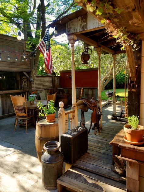 a wooden deck with potted plants and an american flag hanging from the pergolated roof