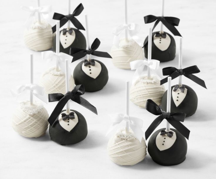 wedding cake pops are decorated with black and white chocolates, tied in bow ties