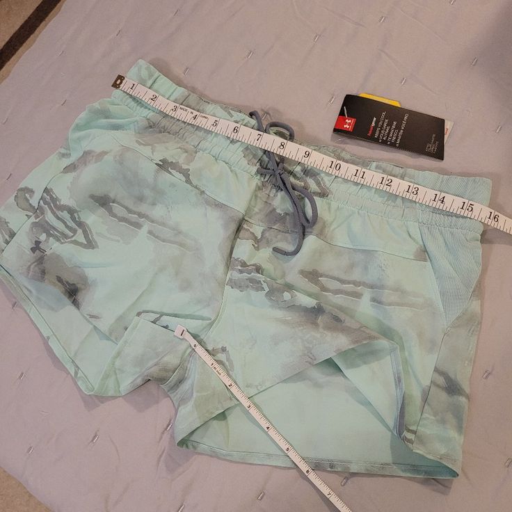 Light Pale Turquoise & Grey Camo Pattern Under Armour Gym Shorts For Summer, Under Armour Bottoms For Gym In Summer, Under Armour Athleisure Shorts For Summer, Summer Blue Activewear With Drawstring, Summer Gym Activewear By Under Armour, Blue Summer Activewear With Drawstring, Light Blue Moisture-wicking Bottoms For Summer, Summer Gym Shorts By Under Armour, Under Armour Workout Shorts For Summer