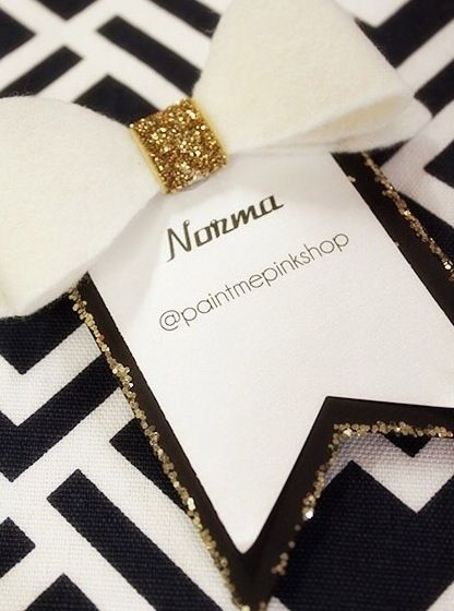 a close up of a white and black bow tie on a shirt with gold sequins