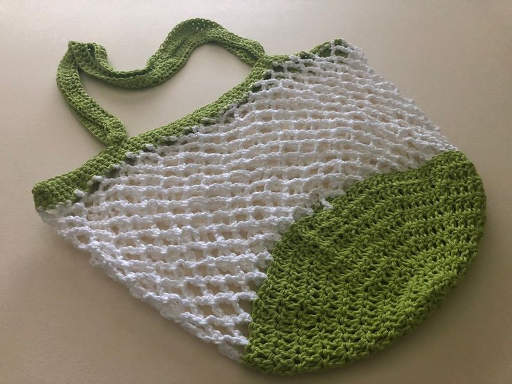 a green and white crocheted bag sitting on top of a table