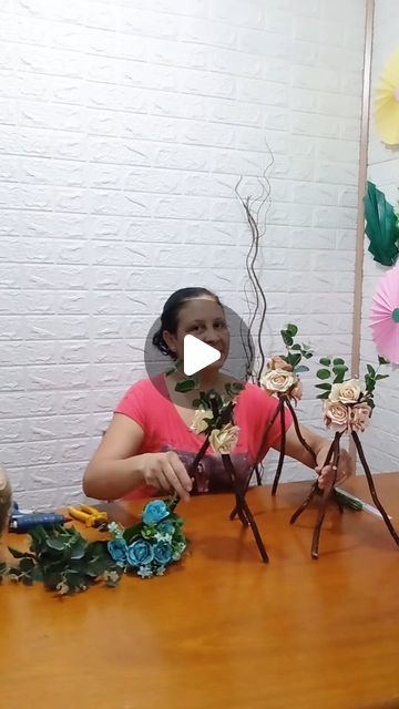 a woman sitting at a table with flowers in front of her