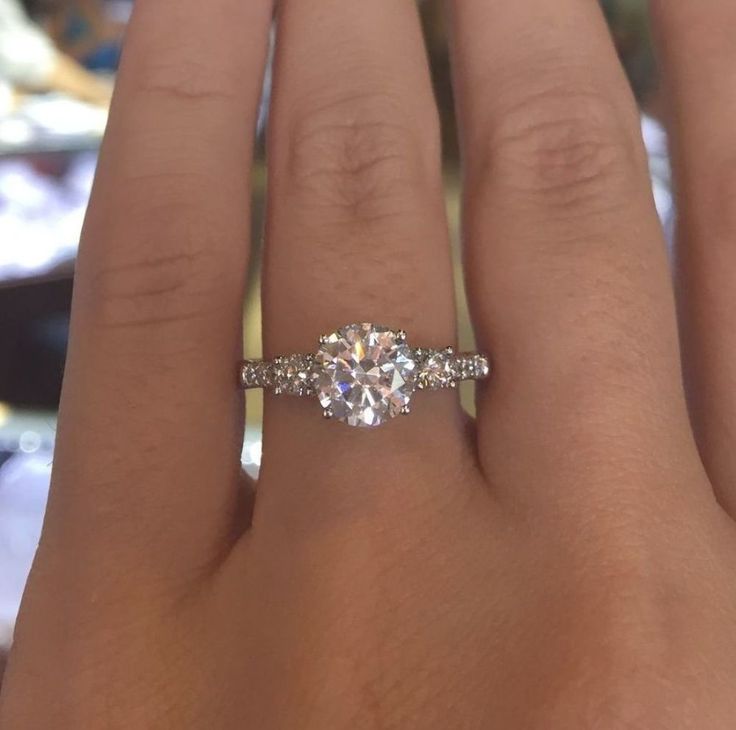 a woman's hand with two engagement rings on it