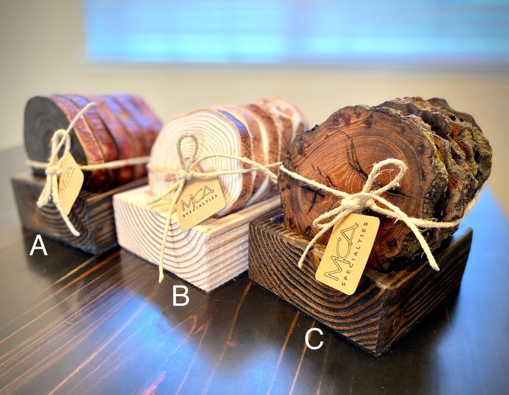 three pieces of wood tied with twine and labeled with labels on them sitting on a table