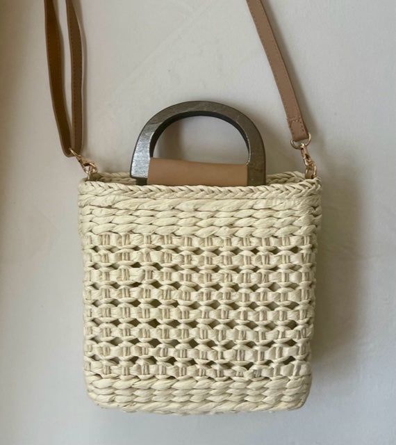 Our Ibiza straw crochet handbag is the perfect addition to your spring/summer wardrobe! This lightweight tote is a must for vacation! Lightweight Straw Woven Handbag Top handles and straps Materials: 100% Paper Straw Drawstring Opening-Polyester Lining Imported Approximately: 7x7.8 in Spring Natural Fiber Beach Bag With Adjustable Strap, Spring Braided Crochet Tote Bag, Spring Jute Beach Bag With Adjustable Strap, Spring Crochet Bag With Handles In Natural Color, Summer Braided Natural Bucket Bag, Spring Crochet Jute Bag With Leather Handles, Summer Cream Open Weave Straw Bag, Braided Natural Bucket Bag For Summer, Summer Crochet Straw Bag With Leather Handles