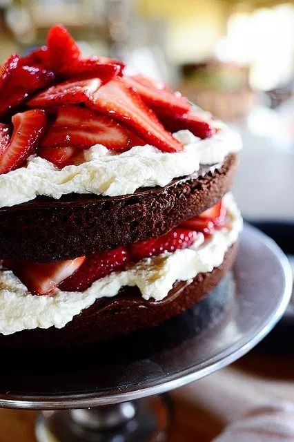 a chocolate cake topped with strawberries and whipped cream