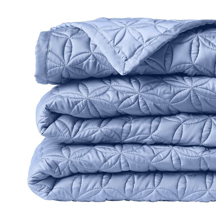 the blue quilted blanket is folded on top of each other