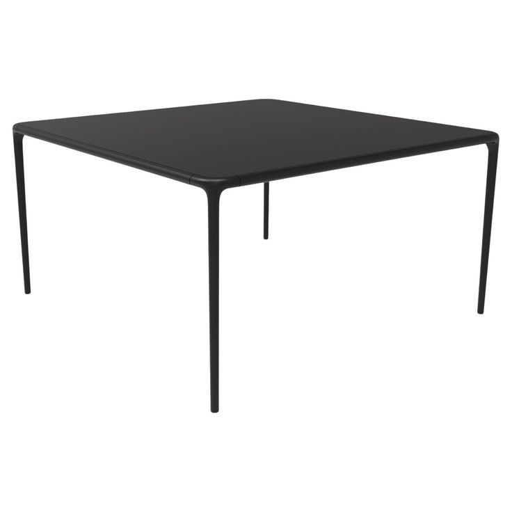 a black square table with metal legs on an isolated white background, viewed from the front